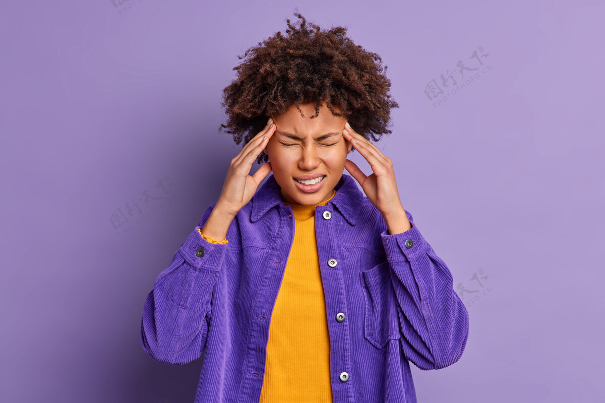 紫色穿着时髦的天鹅绒夹克 美丽的黑皮肤美国黑人妇女摸太阳穴头痛难忍偏头痛人头痛非洲
