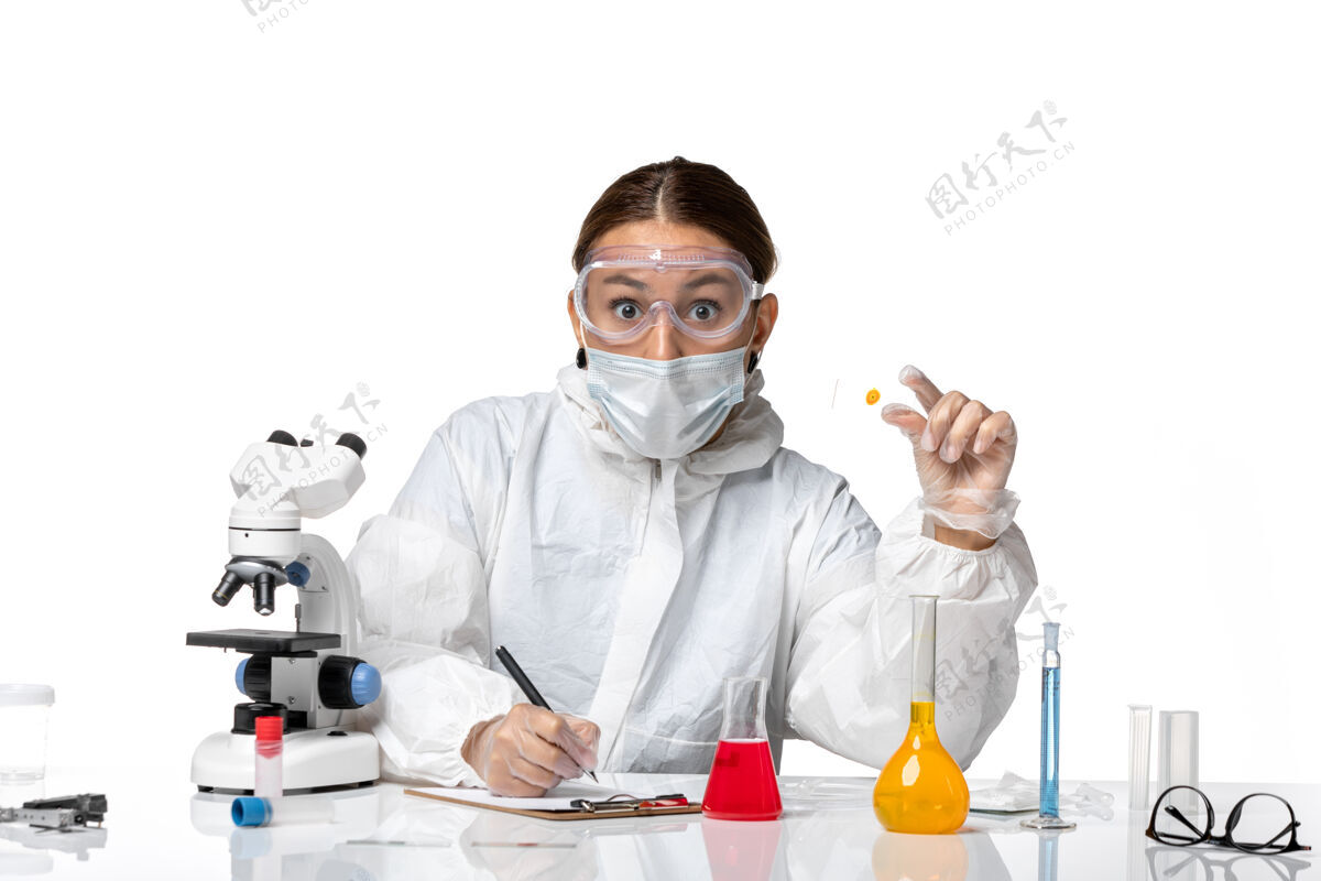 口罩正面图女医生穿着防护服 戴着口罩 在白色背景上写笔记医学病毒-健康大流行病毒实验室笔记防护
