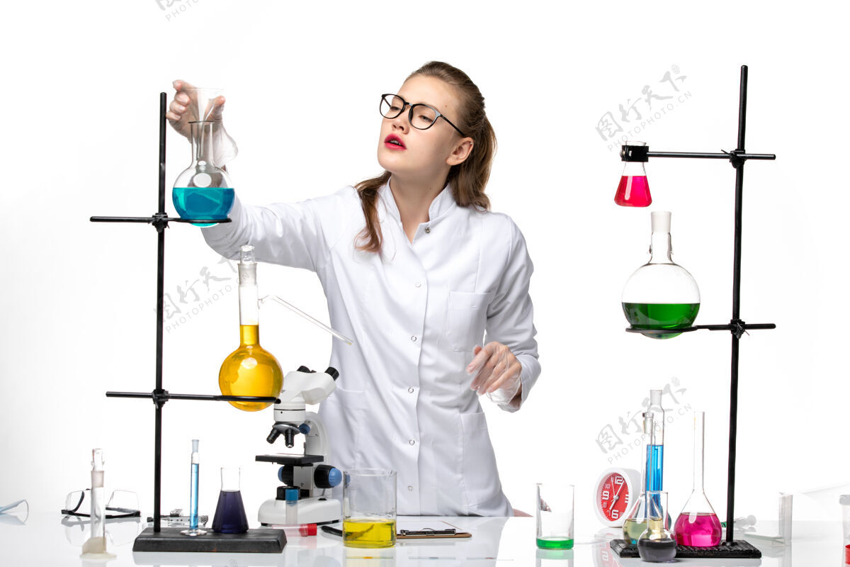 套装前视图穿着医疗服的女化学家在工作过程中用白色背景上的溶液化学大流行的冠状病毒医生医学工作