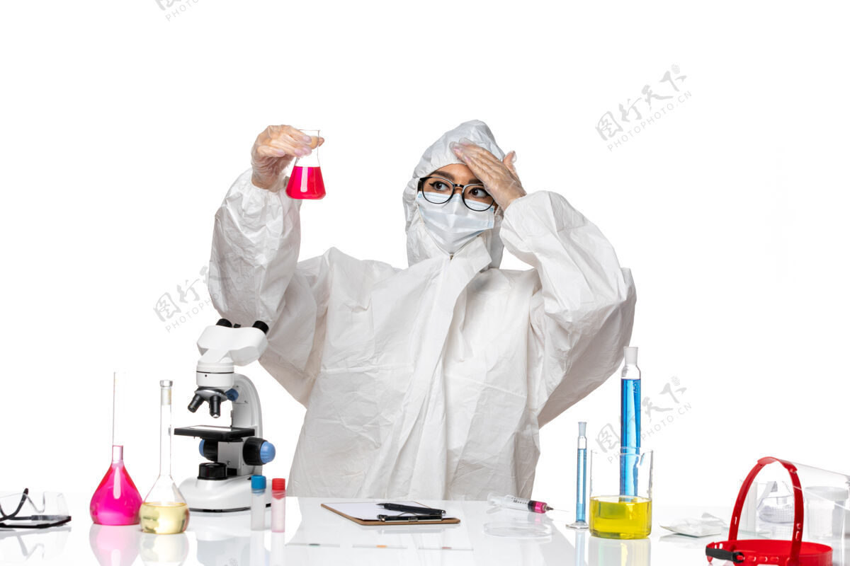 医学前视图穿着特殊防护服的女化学家拿着白色背景上的红色溶液-化学病毒实验室实验室外套防护人