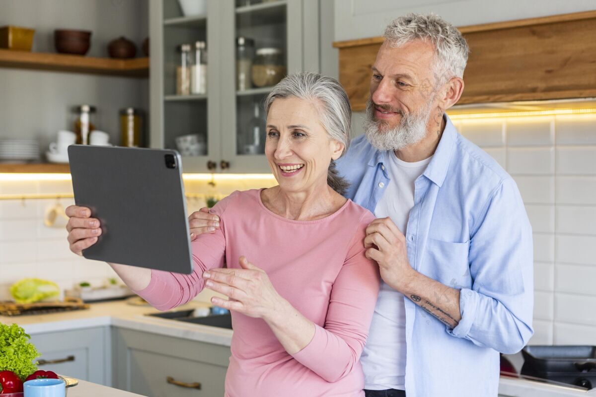水平快乐的老年夫妇与平板电脑中镜头放松内老年人