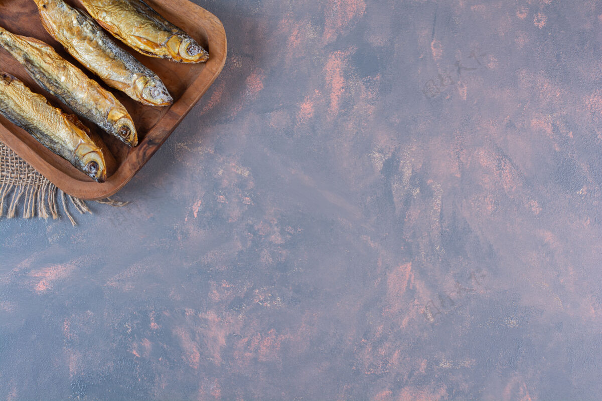 烘焙把柠檬片和咸鱼放在切割板上 放在粗麻布餐巾上 放在大理石表面烧烤烹饪美味