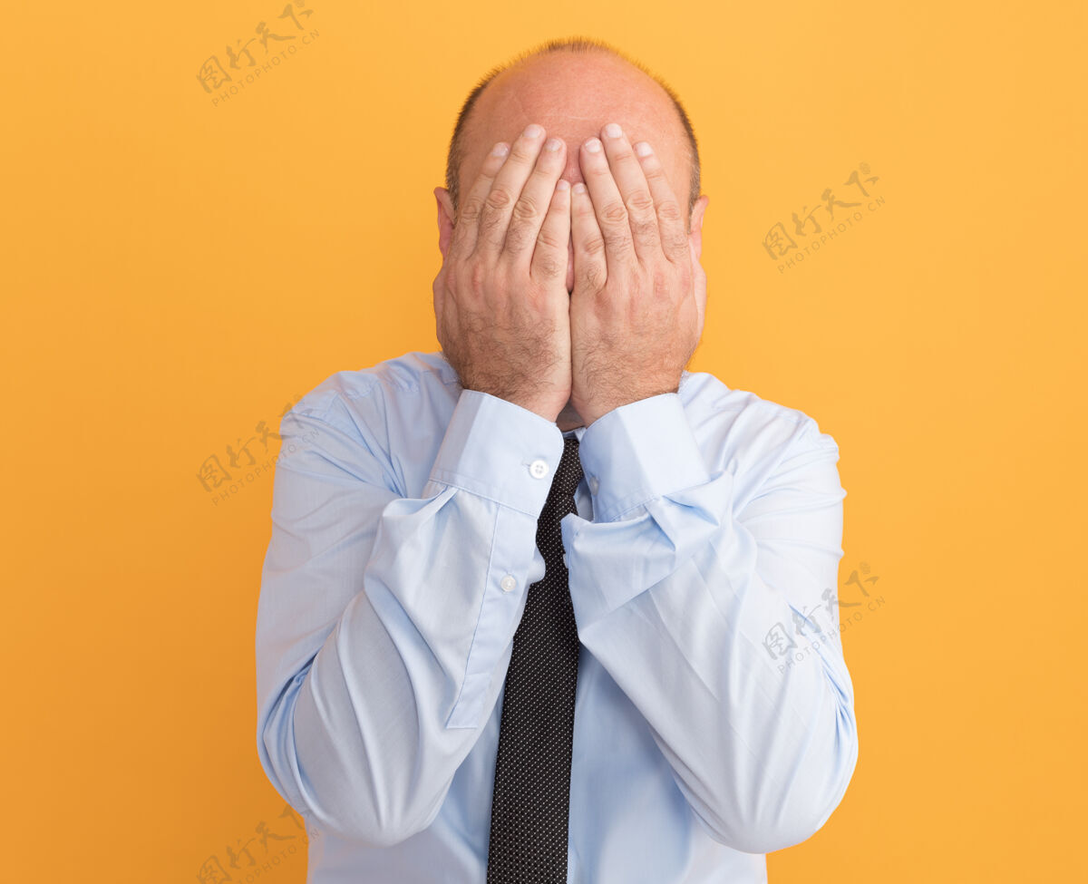 手中年男子身穿白色t恤 脸上打着领带 手孤立在橙色的墙上掩护衣服人