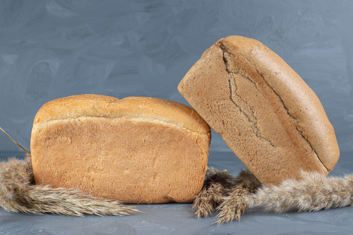 烘焙羽毛草和面包捆在一起放在大理石桌上美味小麦面团