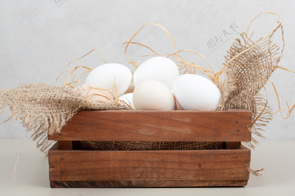 干草新鲜的鸡蛋和干草放在木篮里生的鸡肉生的