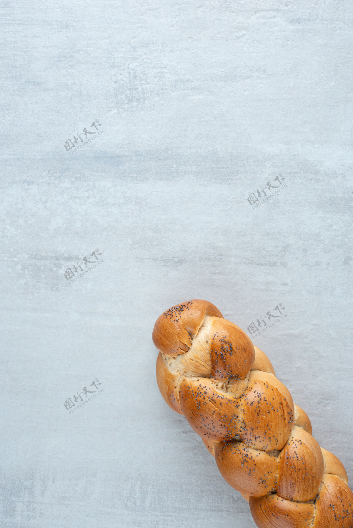 顶视图白色编织的面包放在石头桌上平铺面包美味
