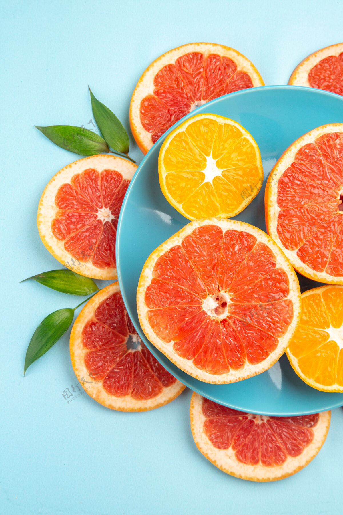 食品蓝色表面上美味的葡萄柚水果片俯视图水果新鲜切片