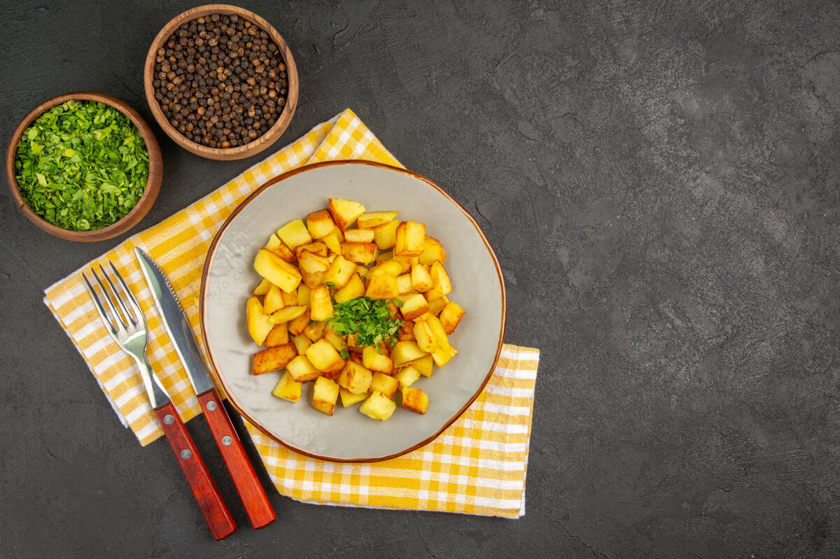 水果在深灰色表面的盘子里 美味的炸土豆俯视图盘子膳食种子