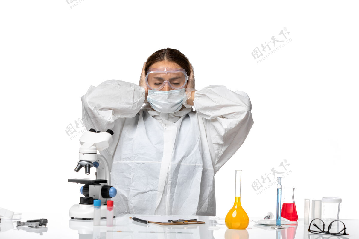 视图正面图白色背景上穿着西装戴口罩头痛的女医生冠状病毒大流行穿着实验室外套专业