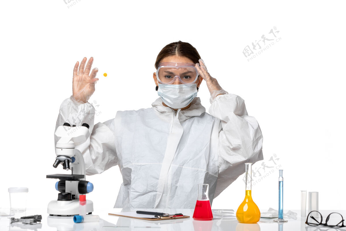 女医生前视图：穿着防护服 戴着面罩的女医生拿着白色背景的医学病毒样本-健康大流行病毒男人专业大流行
