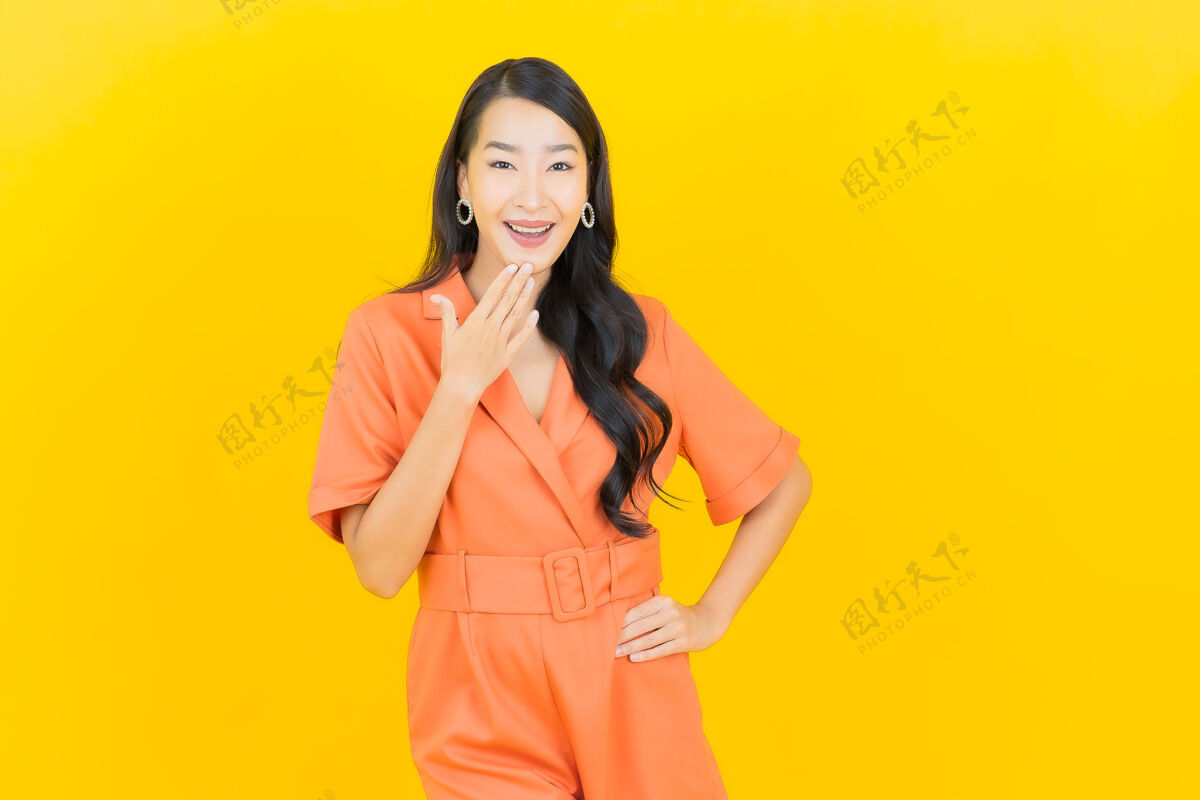 时尚肖像美丽的亚洲年轻女子微笑着行动黄色学生女性成人