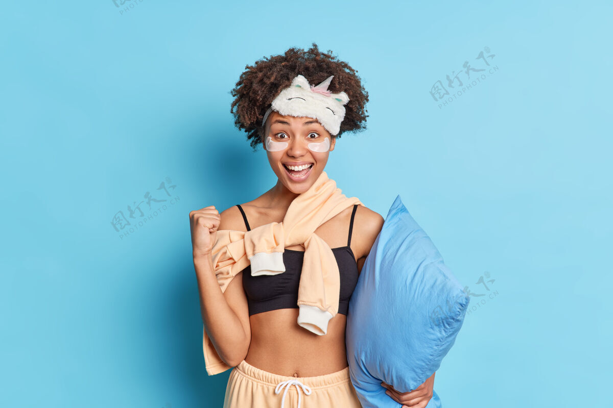 肖像快乐黑皮肤女人的画像举起拳头庆祝某物呆在家里对自己孤立的微笑非洲女孩蓝色