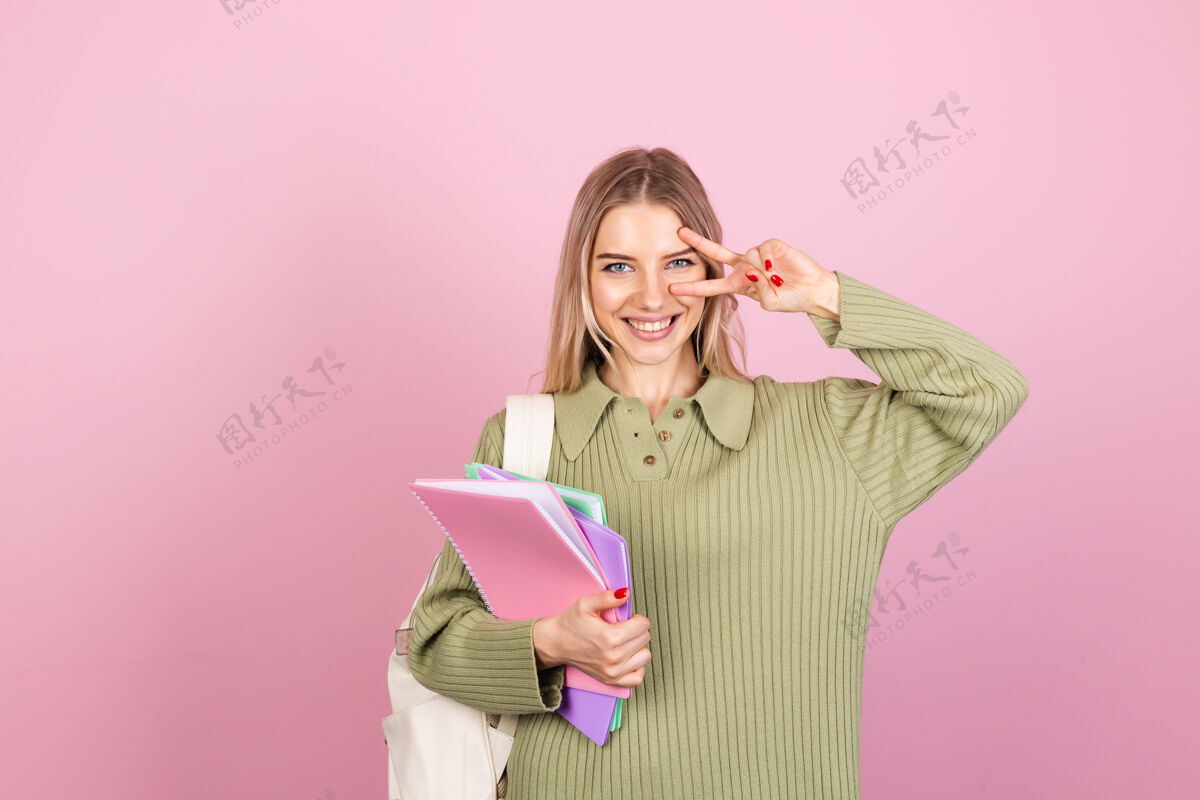 欢呼粉色墙上穿着休闲毛衣的漂亮欧洲女人快乐青少年情感