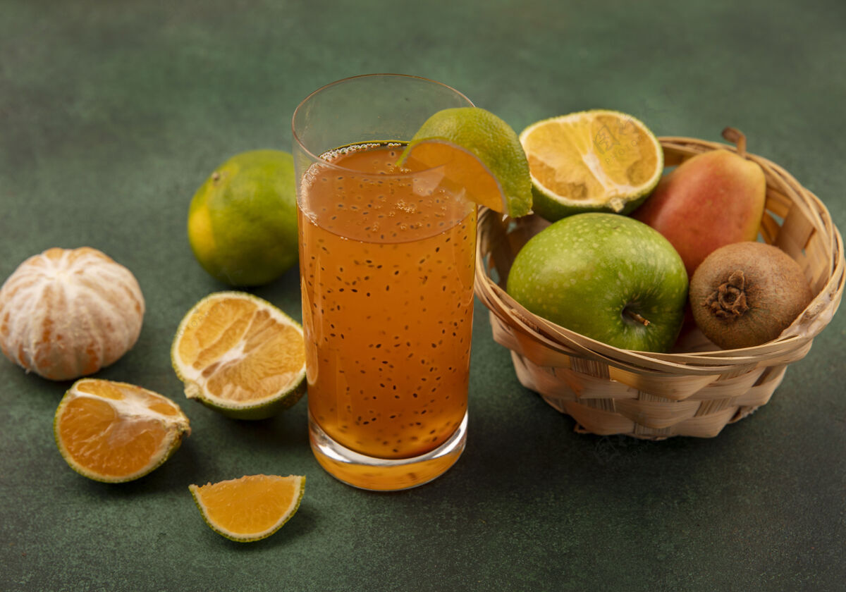 果汁健康新鲜水果的俯视图 如苹果梨猕猴桃放在桶里 新鲜果汁放在玻璃杯里 橘子被隔离玻璃苹果水果