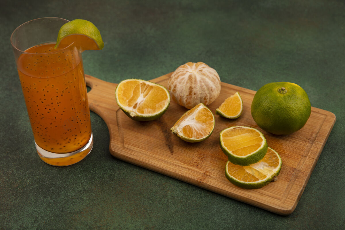 木头顶视图新鲜开放和切碎的橘子在木制厨房板上与新鲜果汁在一个玻璃杯上果汁新鲜开的