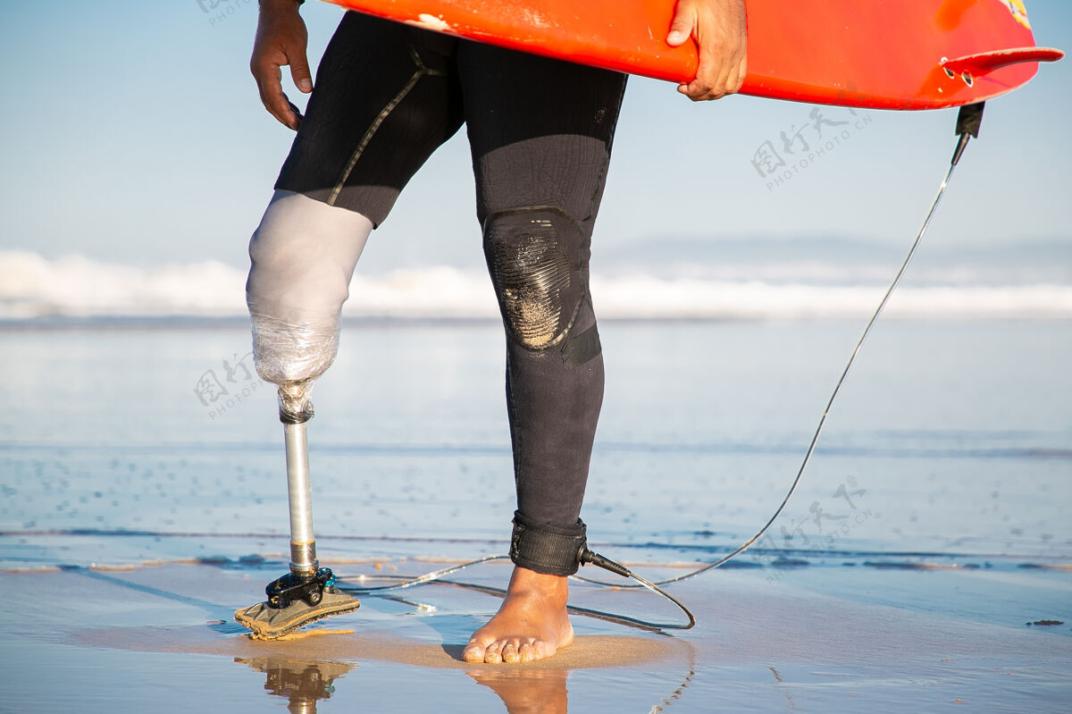 海景短款男冲浪者站在海边冲浪板水男活跃