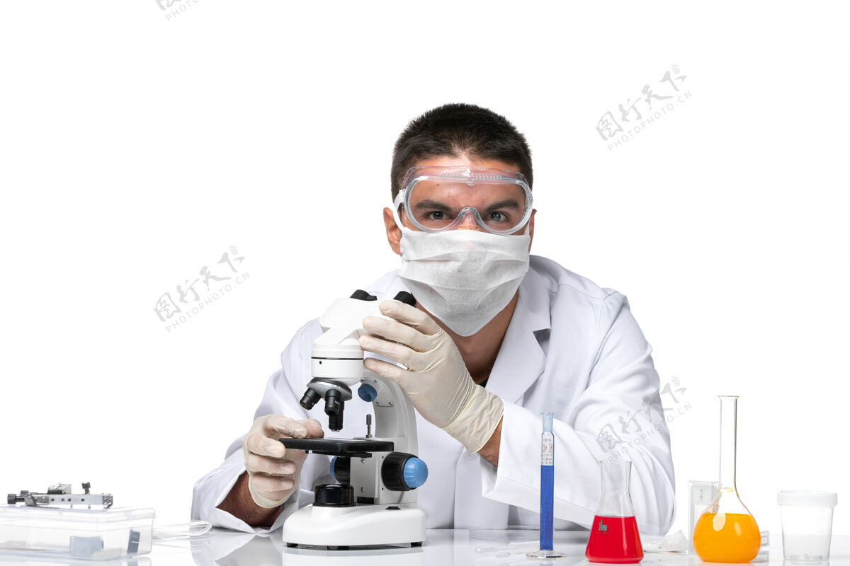 男医生前视图：男医生穿着白色医疗服 戴着面罩 在空白处使用显微镜面具实验室外套到期
