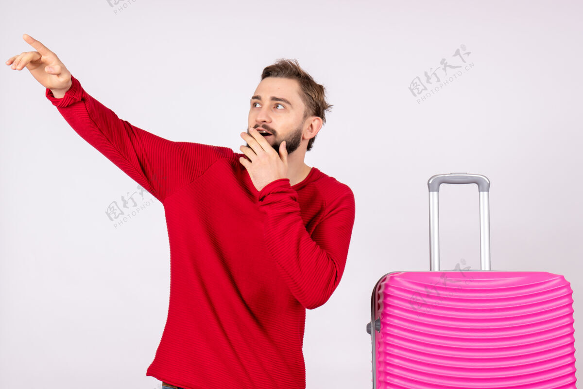 游客正面图白色墙上带着粉色包的年轻男性旅行照人色度假航班航行夏季风景微笑肖像