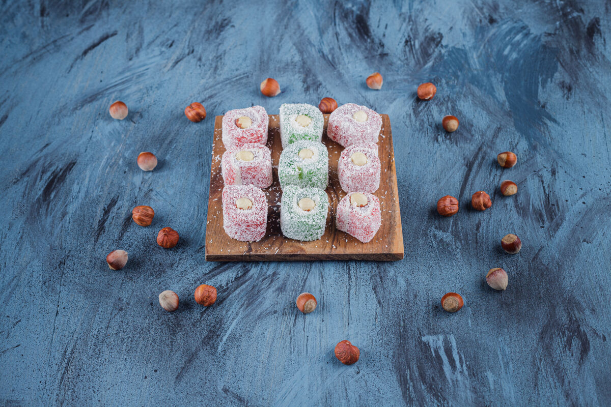 品种美味的五颜六色的甜点和坚果放在木板上烹饪糖果罗库