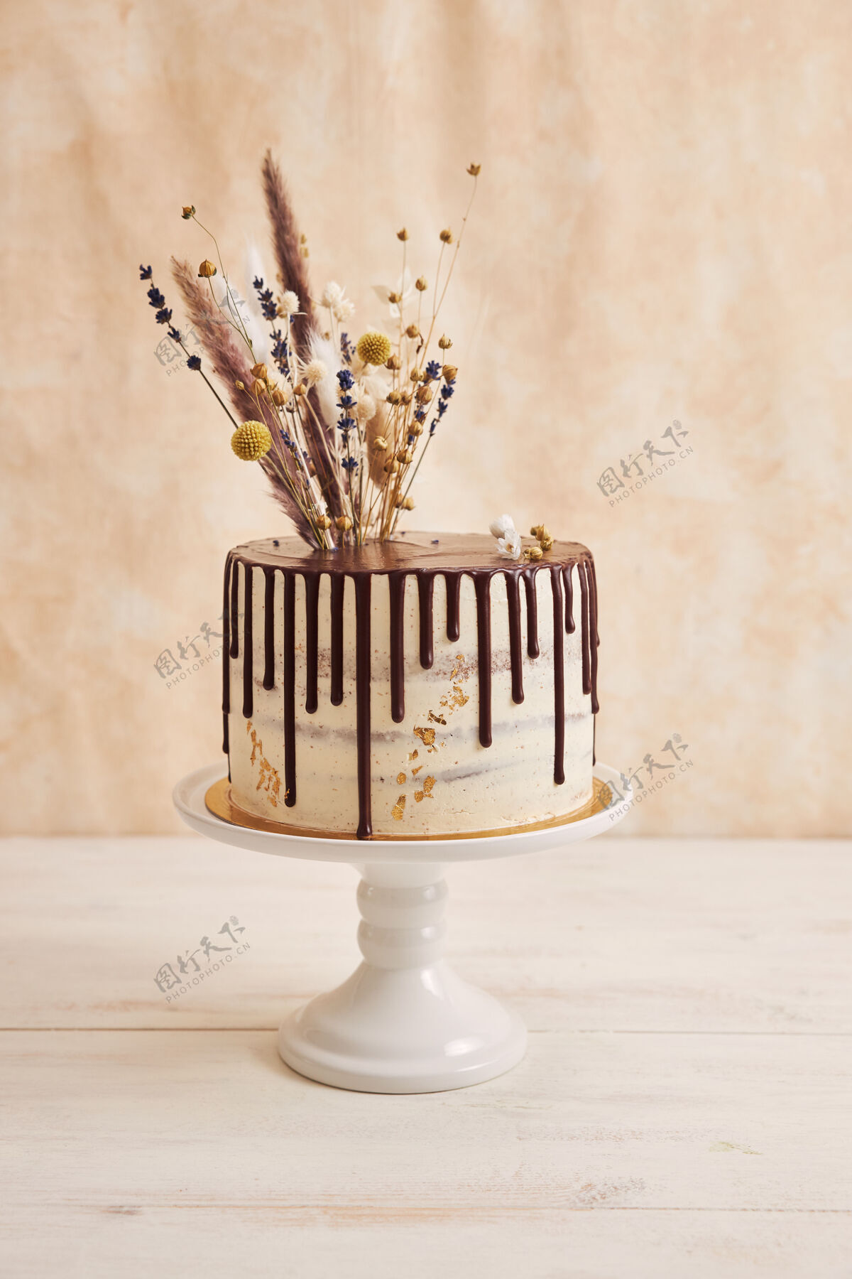 美食垂直拍摄美味波西米亚蛋糕与巧克力滴和鲜花上的黄金装饰小吃烘焙糖