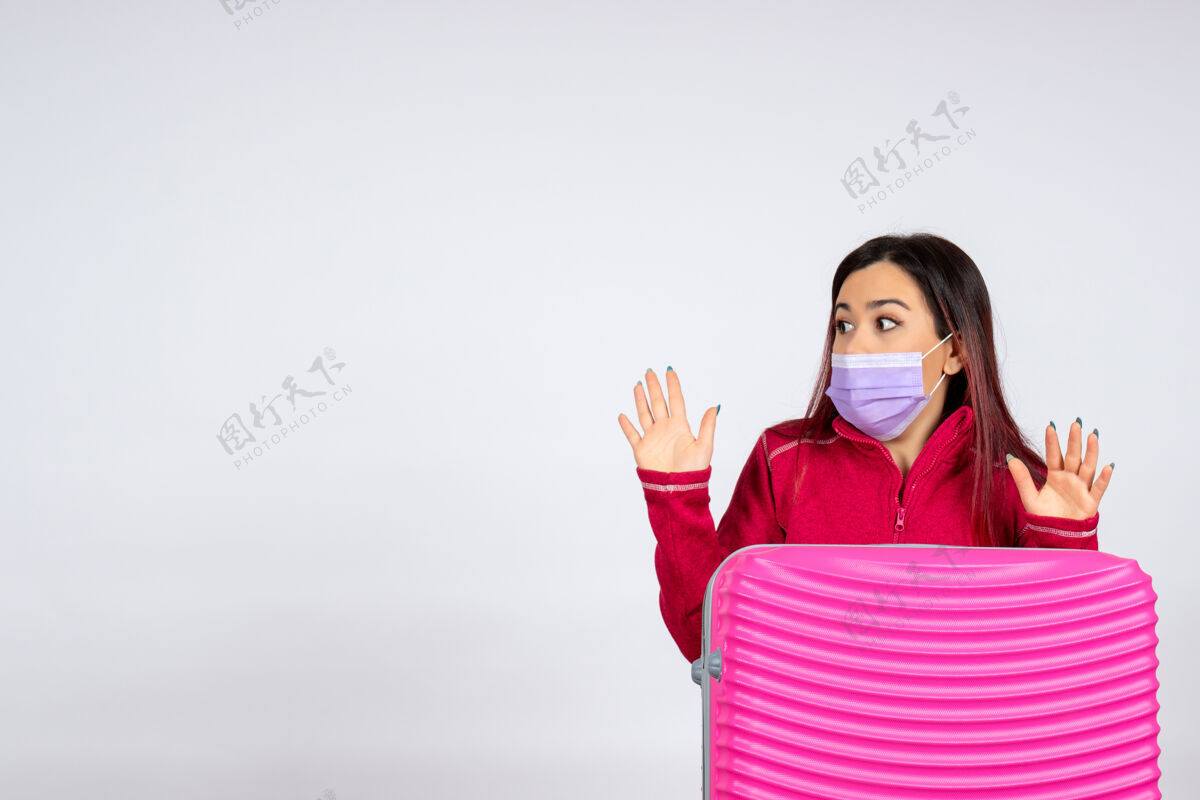 女人正面图年轻女性带着粉色包在白墙面具上病毒女性度假彩妆大流行之旅病毒年轻女性假期