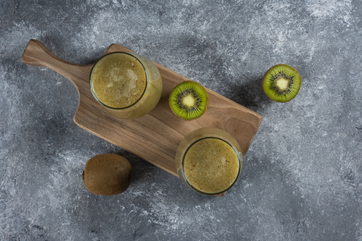美味两杯美味的猕猴桃汁放在木板上生的自然多汁