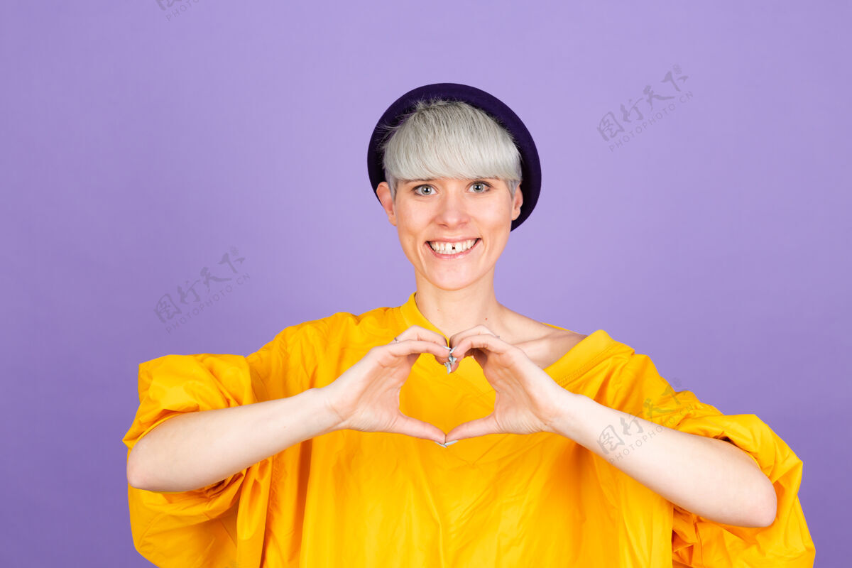 手指紫色墙上的时髦欧洲女人表情关怀快乐