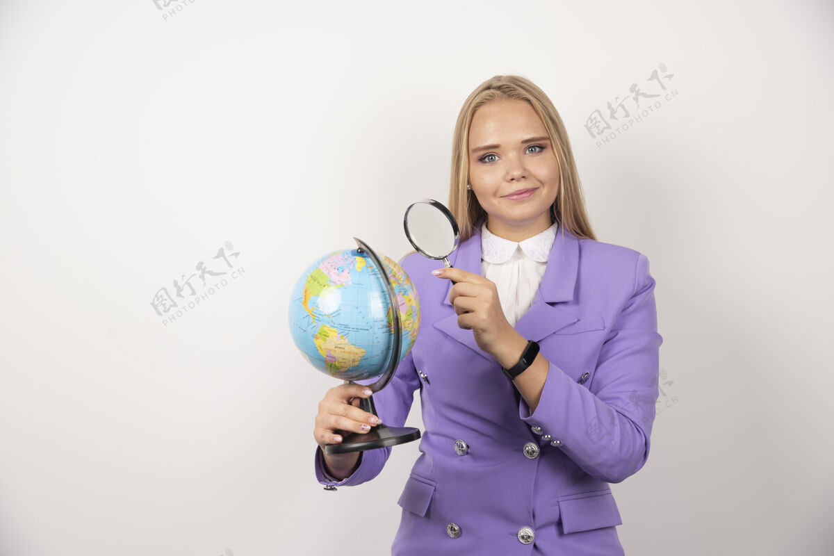 工作金发老师用放大镜看着地球仪高质量的照片地球仪职业微笑