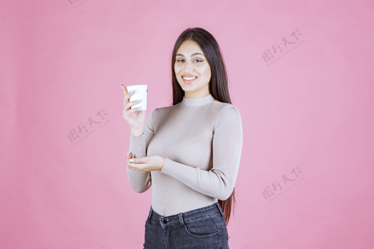服装女孩拿着一个白色的一次性咖啡杯 推销它或闻到新鲜的咖啡广告女人成人