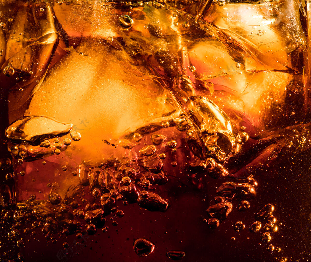 玻璃深色可乐背景下冰块的特写镜头玻璃壁上有泡沫和大气泡的清凉甜味夏季饮料的质地起泡或漂浮到表面顶部单一新鲜透明