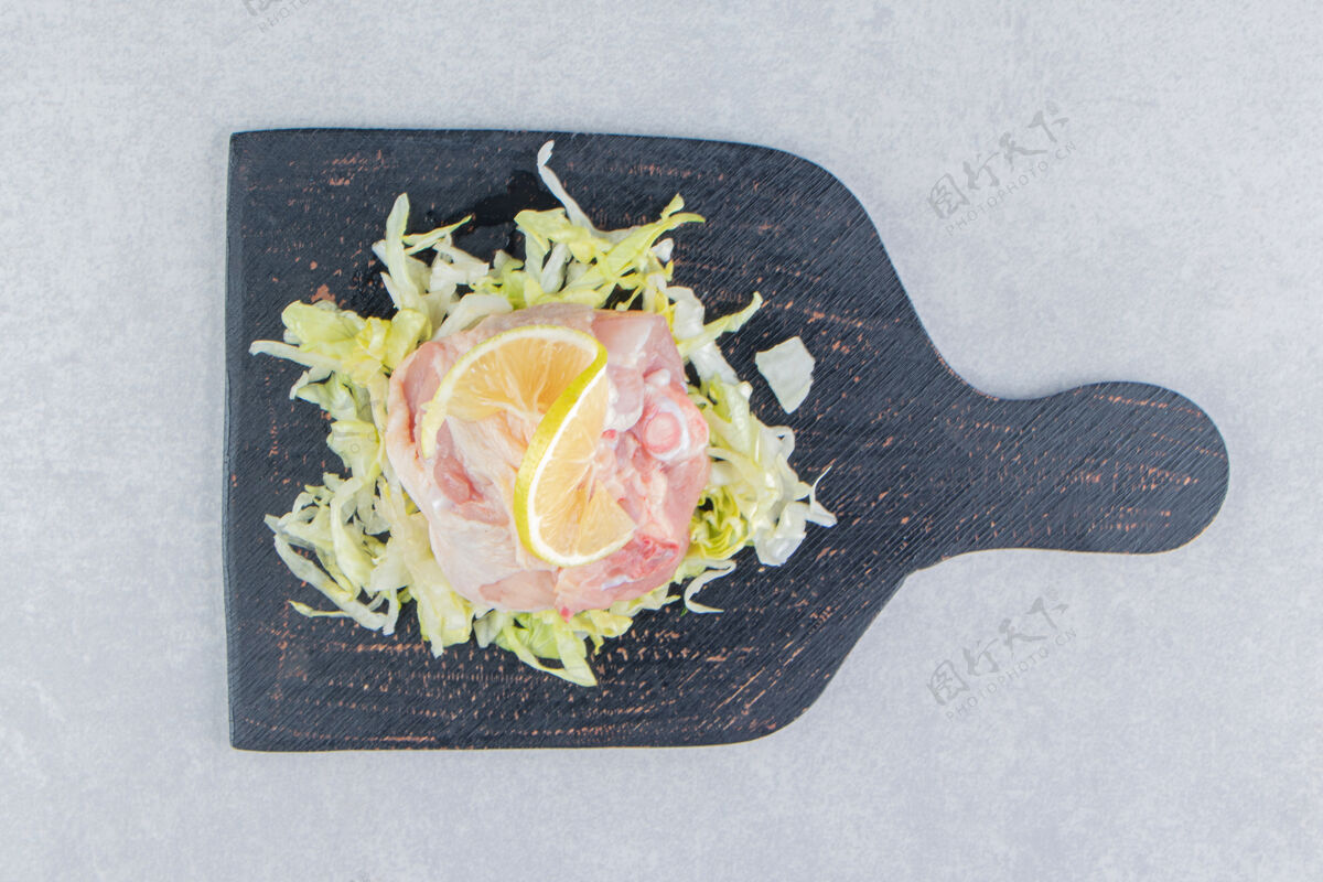 营养把柠檬和青菜切成片 在白板上放肉健康生的板