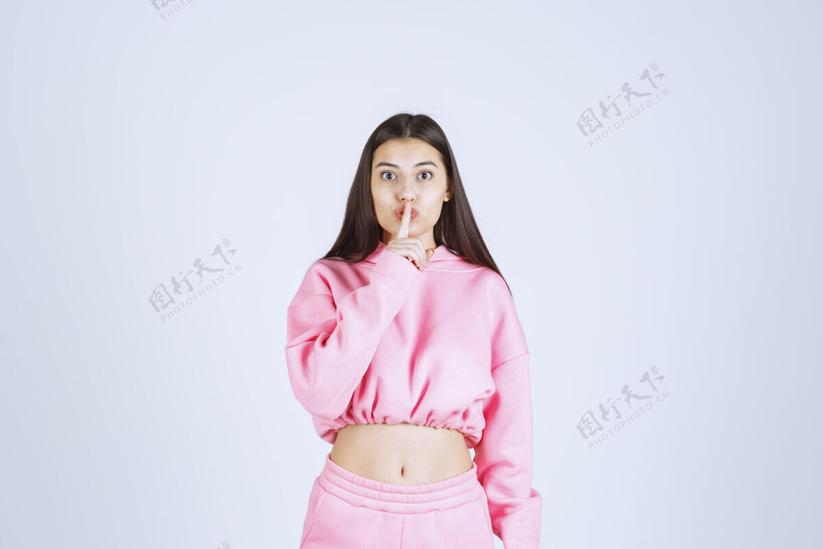 姿势穿粉红色睡衣的女孩要求安静女性人类装束