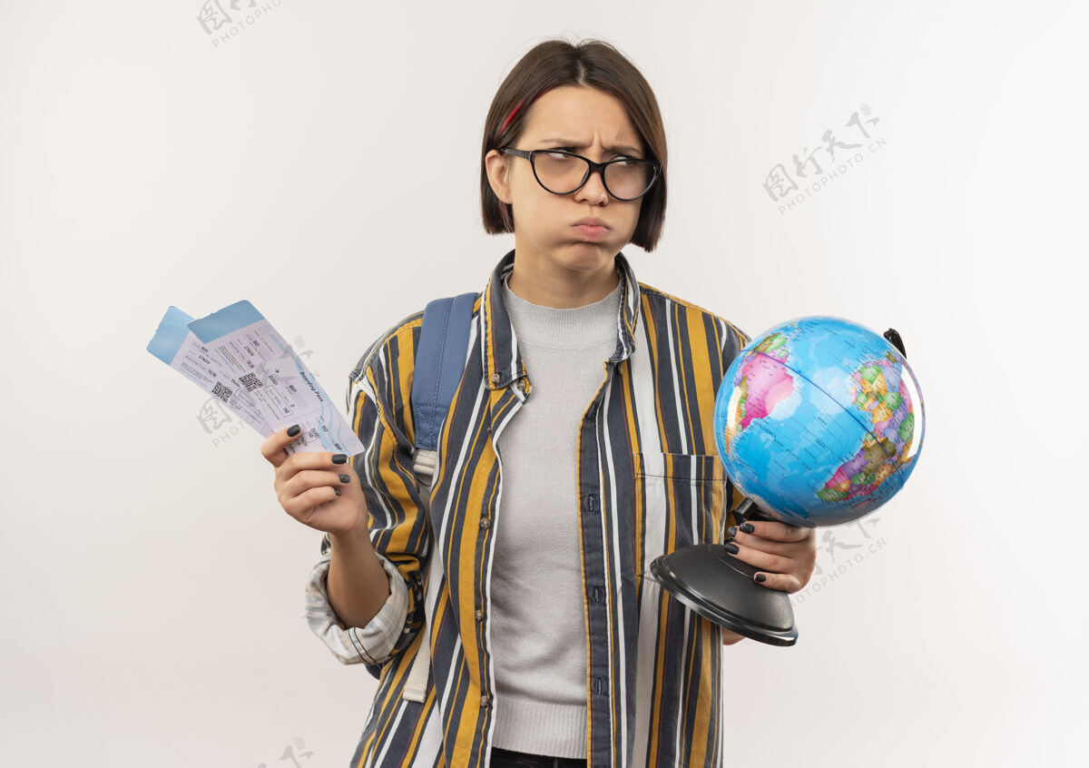 机票一个戴着眼镜 背着包 拿着飞机票和地球仪的年轻学生女孩 看着隔离在白色背景上的一面眼镜背部学生