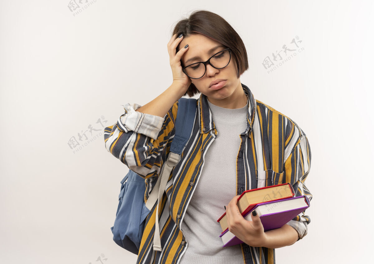 累了疲惫的年轻女学生戴着眼镜 背着书包 手放在头上 闭着眼睛 隔离在白色背景上包眼镜年轻