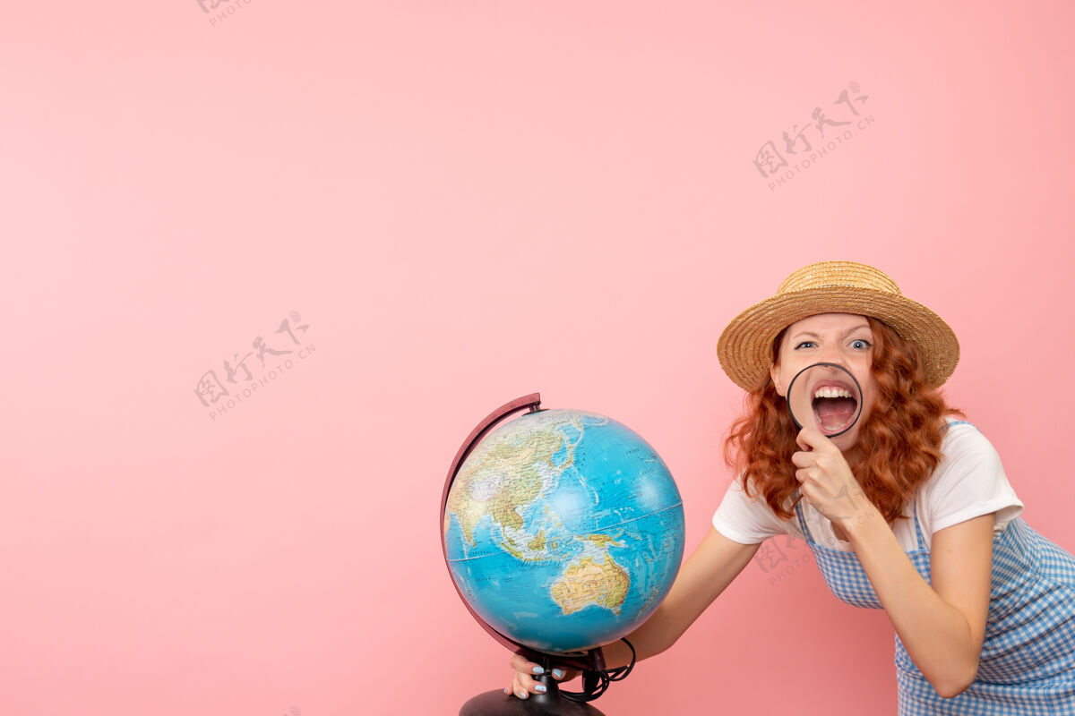 女游客前视图女性游客用放大镜探索地球仪粉色成人地球