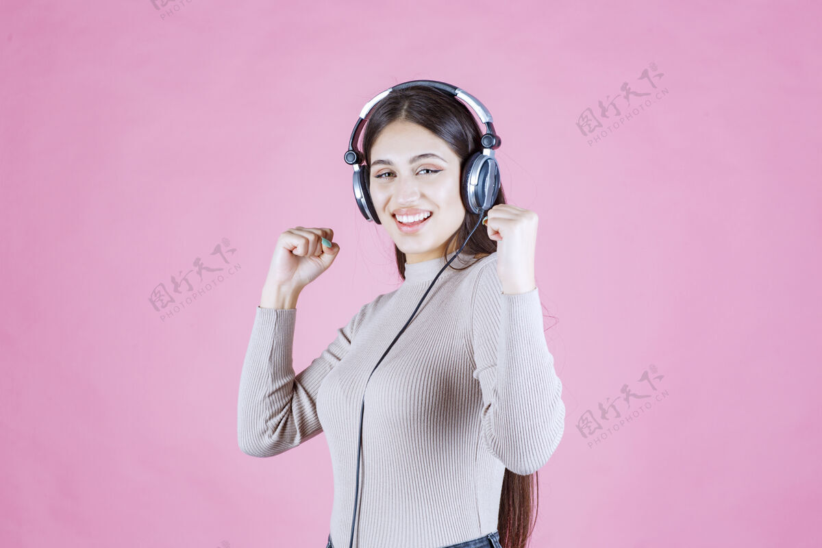 轨道戴着耳机的女孩听着音乐 感觉很开心休闲服装人类
