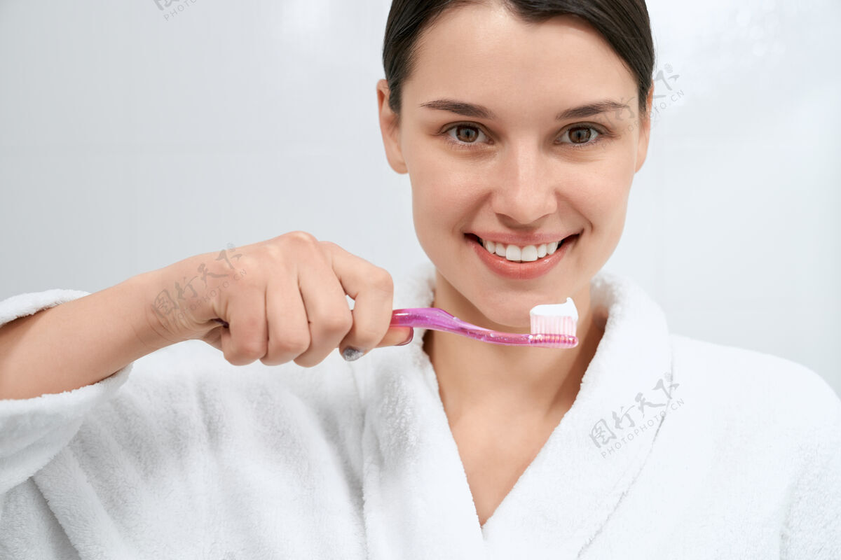 卫生微笑的女人在浴室里准备刷牙刷子牙齿皮肤