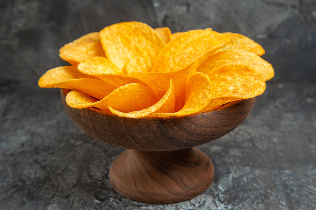 薯片灰色桌子上棕色碗里装饰成花朵形状的薯片侧视图食物饮食形状