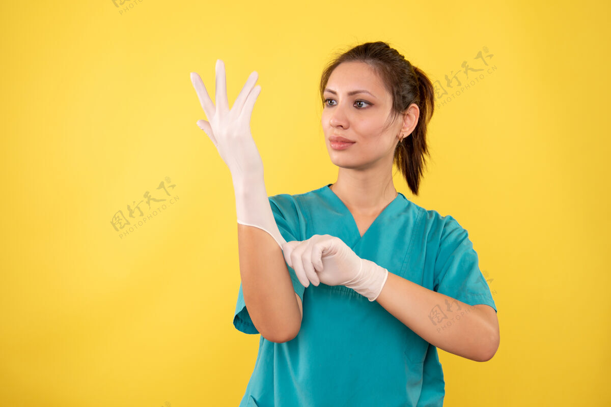 正面前视图黄色背景上戴手套的女医生视图黄色一