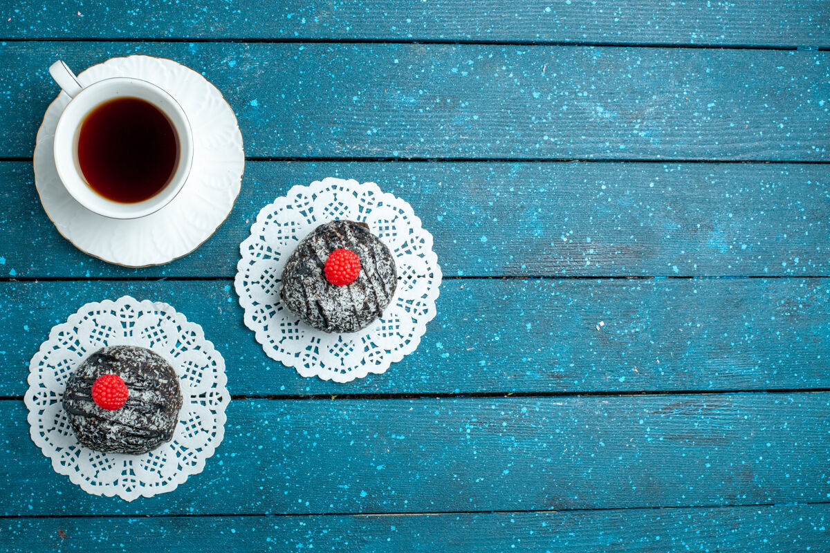 茶俯瞰美味的巧克力球和一杯茶在一个蓝色的乡村书桌上茶蛋糕饼干饼干甜乡村饼干天气