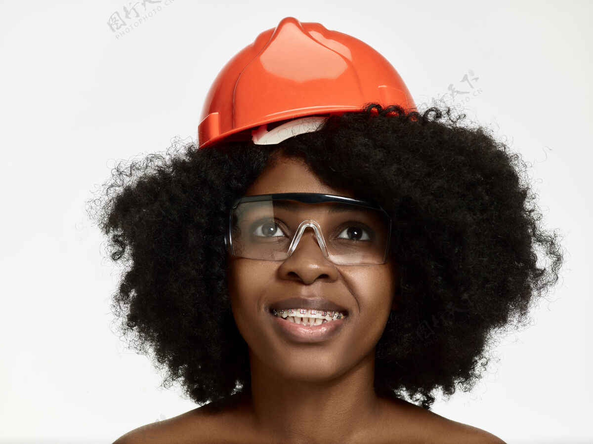 女人戴着橙色头盔的自信女工画像成功微笑女性