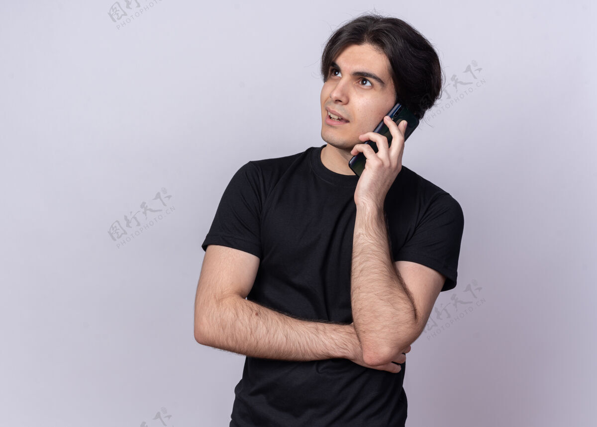 年轻人印象深刻看边年轻帅哥穿着黑色t恤讲电话隔离在白墙上T恤小伙子电话