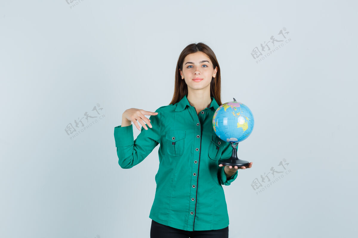 性感穿着衬衫的年轻女士拿着地球仪 指着一边高兴地看着前方前面健康健康