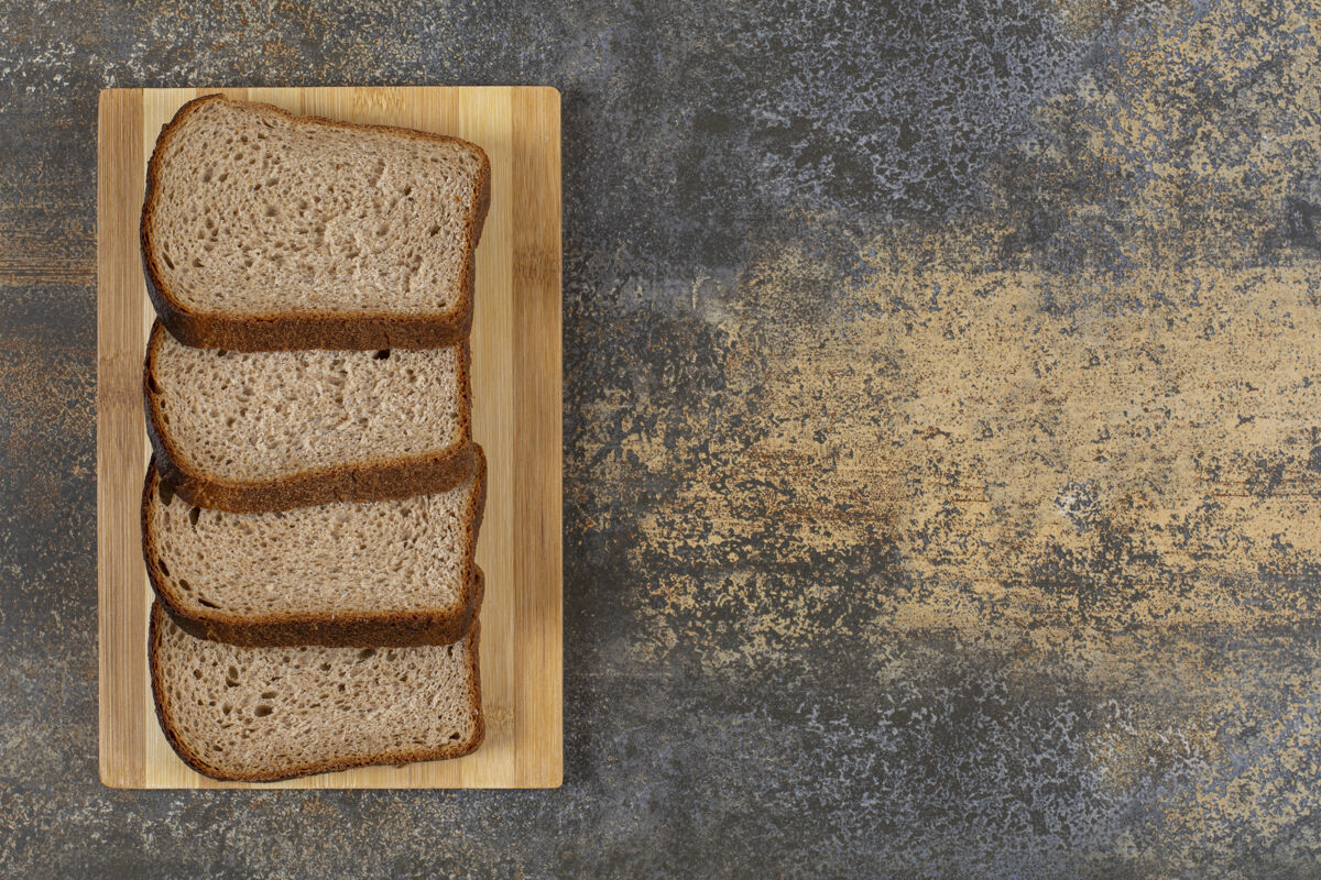 黑麦把新鲜黑麦面包片放在木板上面包皮早餐新鲜