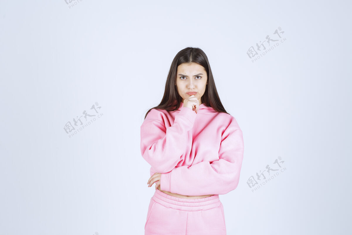 计划穿粉红色睡衣的女孩看起来既困惑又体贴工人没有经验照片