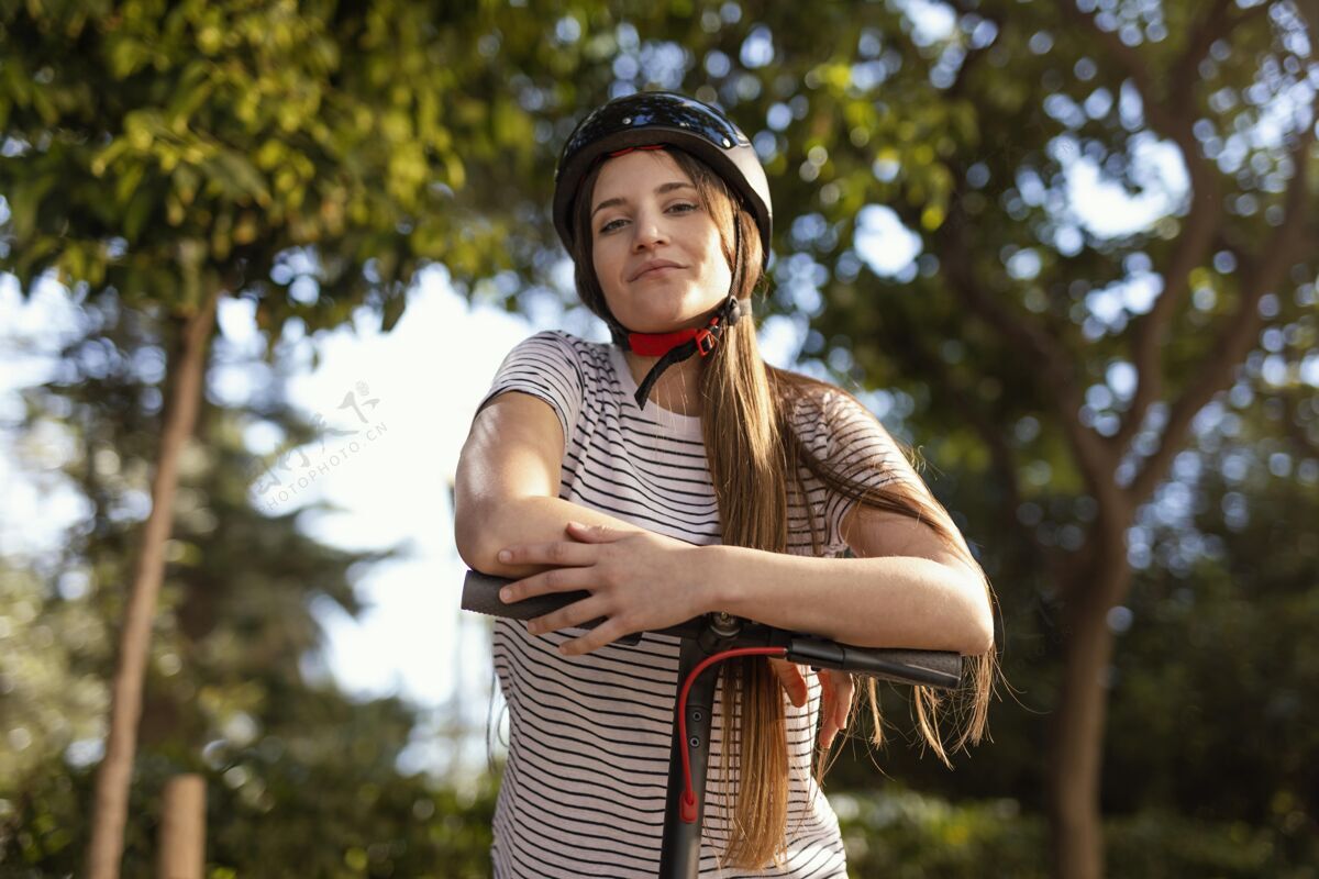 城市一个年轻女子在公园里骑着电动滑板车电力科技车轮