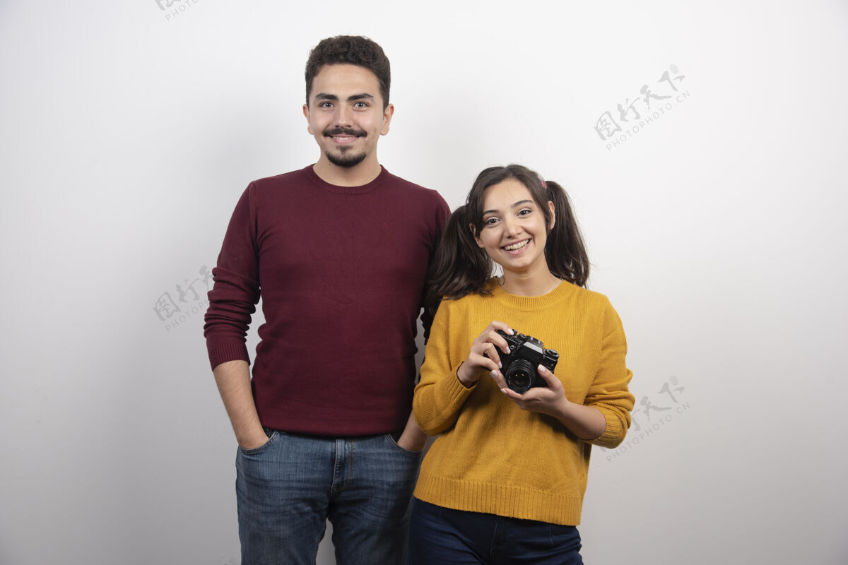 男人站在旁边拿着相机的年轻女子休闲关系在一起