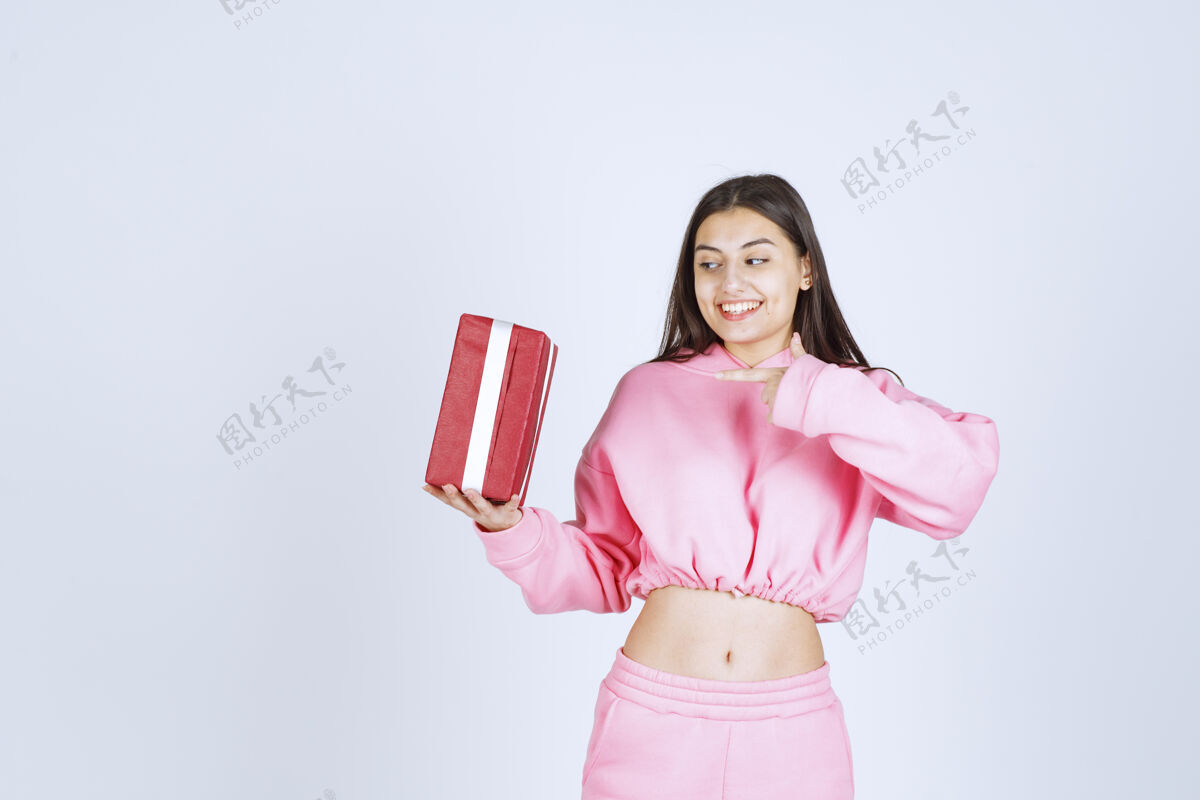 工人穿着粉色睡衣的女孩手里拿着一个红色长方形礼盒 看上去很满意模特聪明积极