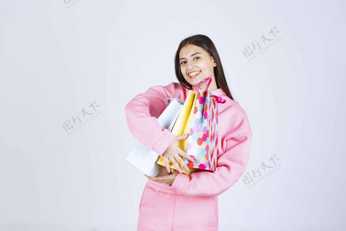 人类女孩抱着五颜六色的购物袋 感觉很积极摄影姿势年轻