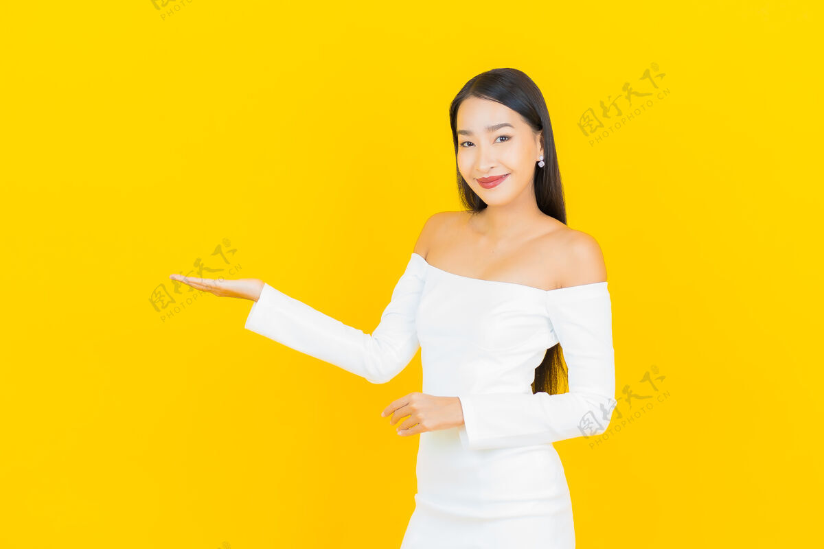 西装美丽的亚洲年轻商业女性在黄色墙壁上穿着白色裙子微笑的画像年轻微笑美丽